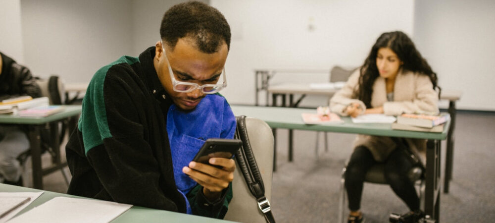 Jongeren in klaslokaal met smartphones