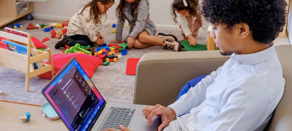 Kind met laptop, met spelende kinderen op de achtergrond media ukkie dagen