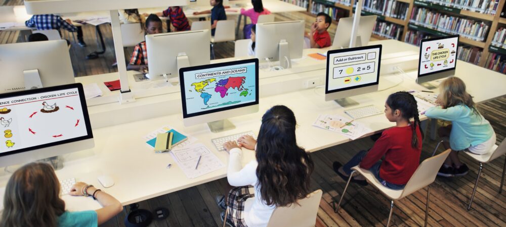 Kinderen in een bibliotheek achter computers