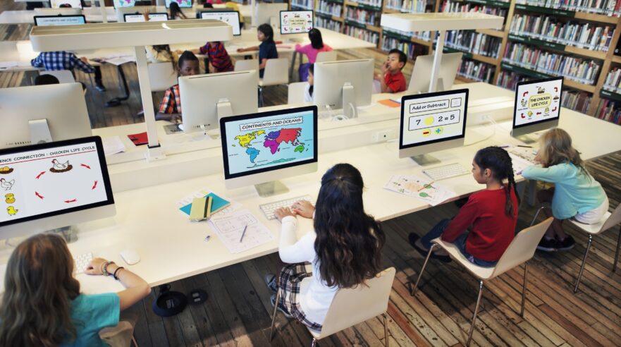 Kinderen in een bibliotheek achter computers