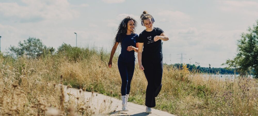 Twee mensen joggen, een iemand kijkt op een smartwatch