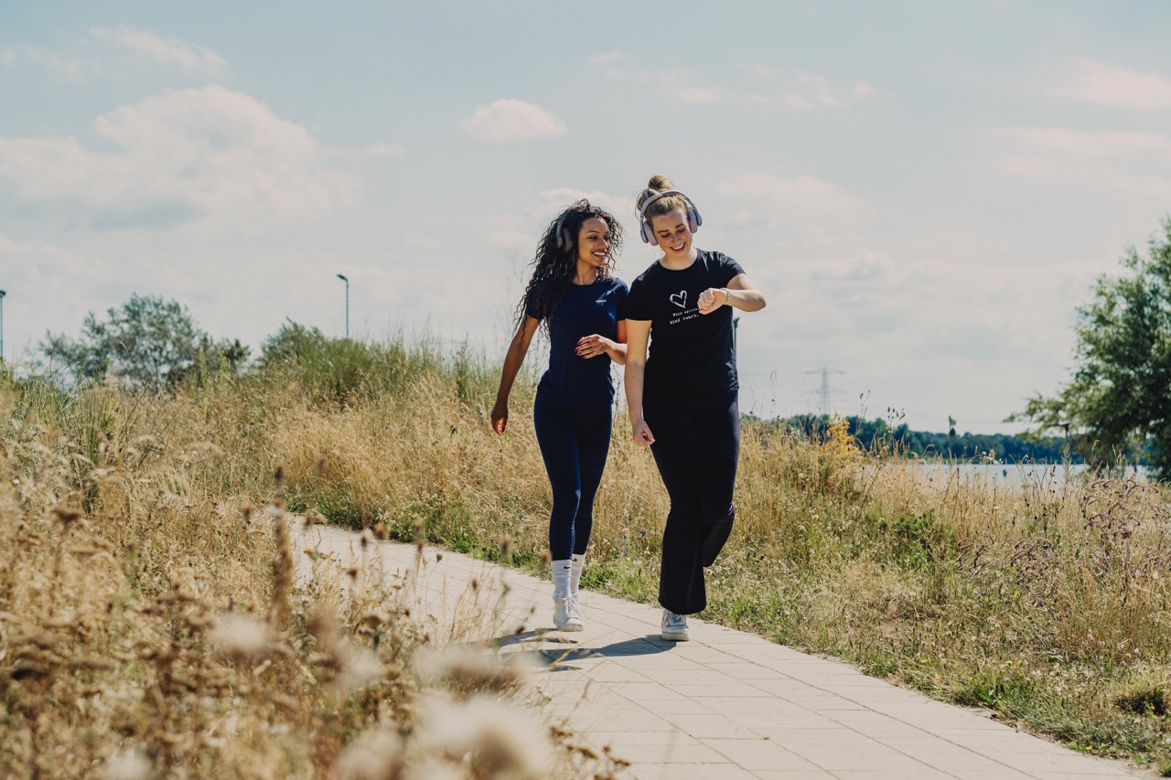 Twee mensen joggen, een iemand kijkt op een smartwatch